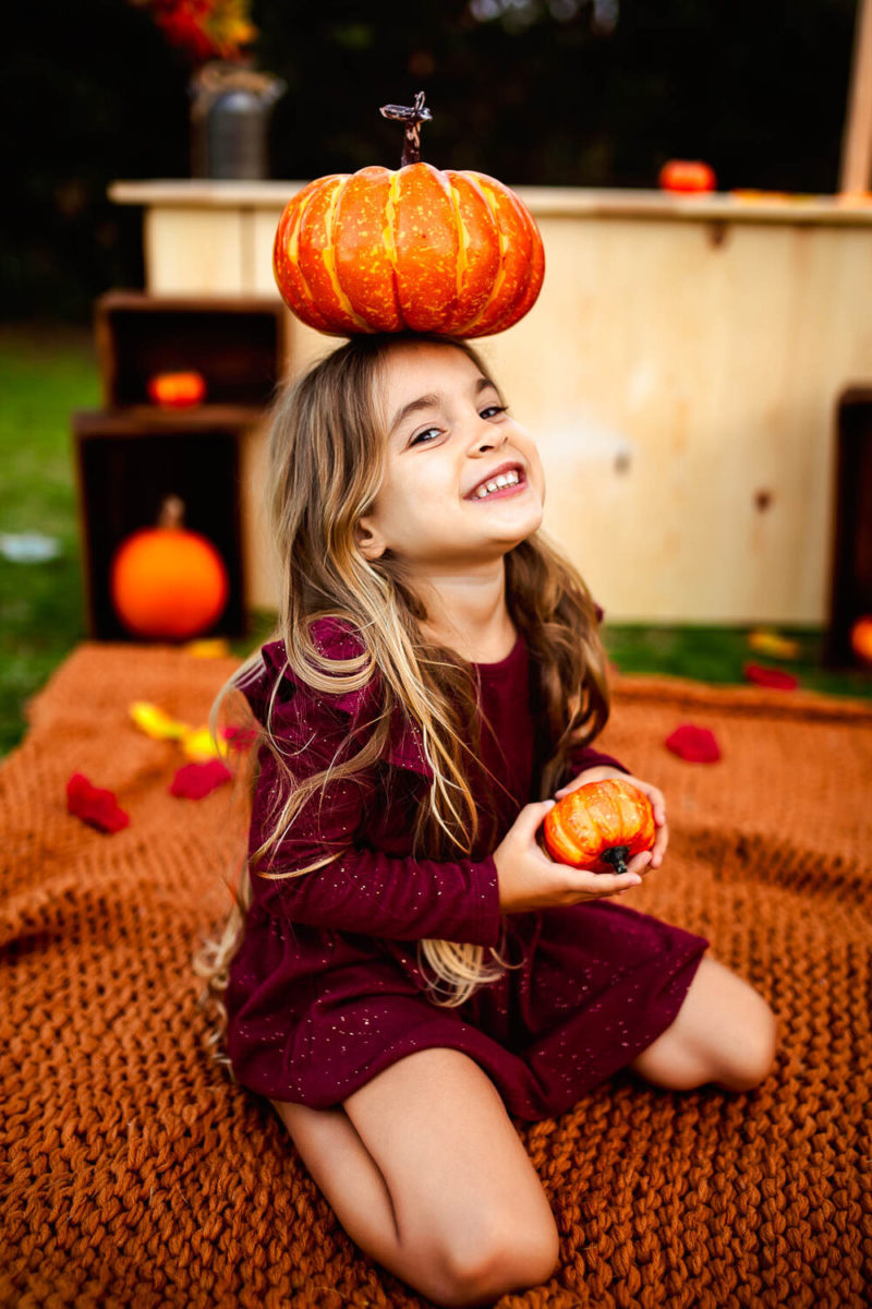 girl with pumpkin on her head