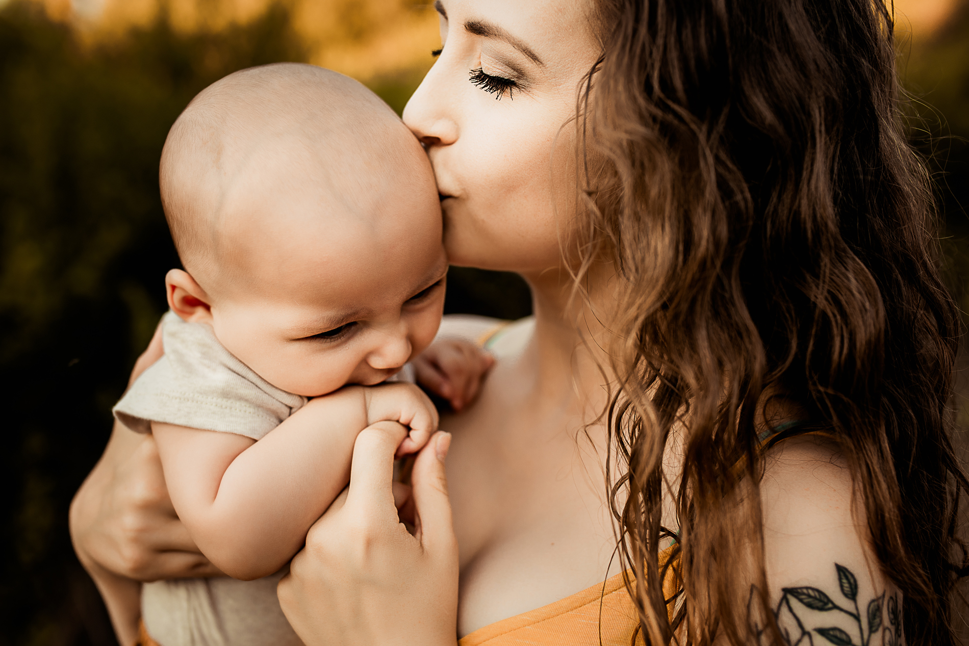 family photography, mother kisses baby on side of the head